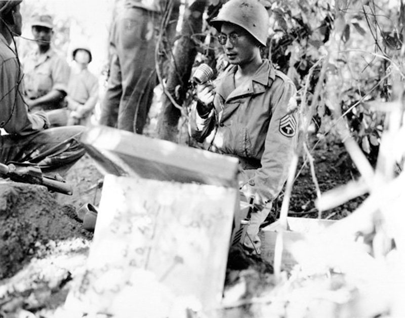 BURMA, 1944: In the jungle near Bhamo, Kenny Yasui, of Los Angeles, uses a loudspeaker to call for Japanese troops to surrender. Yasui earned a Silver Star for capturing 16 Japanese troops on a river island. He swam out to the island with some GIs and, posing as a Japanese colonel, ordered the holdouts into formation and had them turn in their arms. To get back across the river, he had the new POWs pull him on a raft. National Archives photo 
