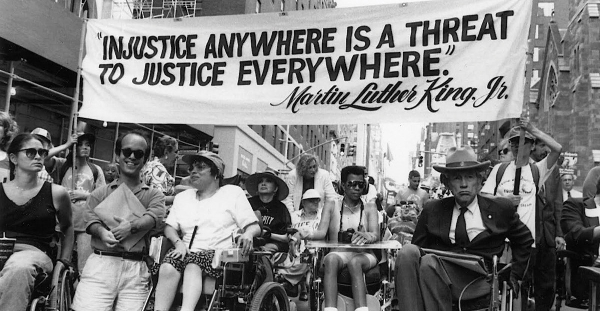 Disability right leaders protest for section of 504 of the Rehabilitation Act. These activists were holding a spreading banner bearing a quote by MLK junior. 